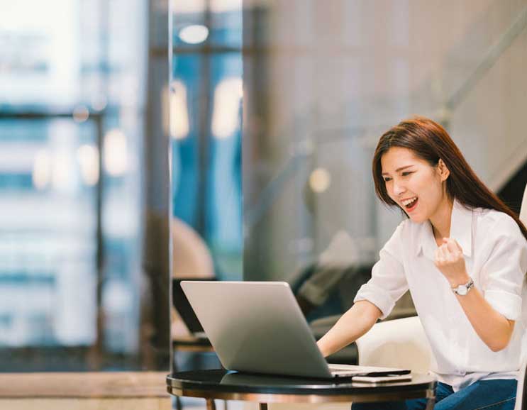 A white shirt woman expressed her happiness, symbolizing the success of digital marketing strategies, increasing their online presence through website design and getting more traffic on the website